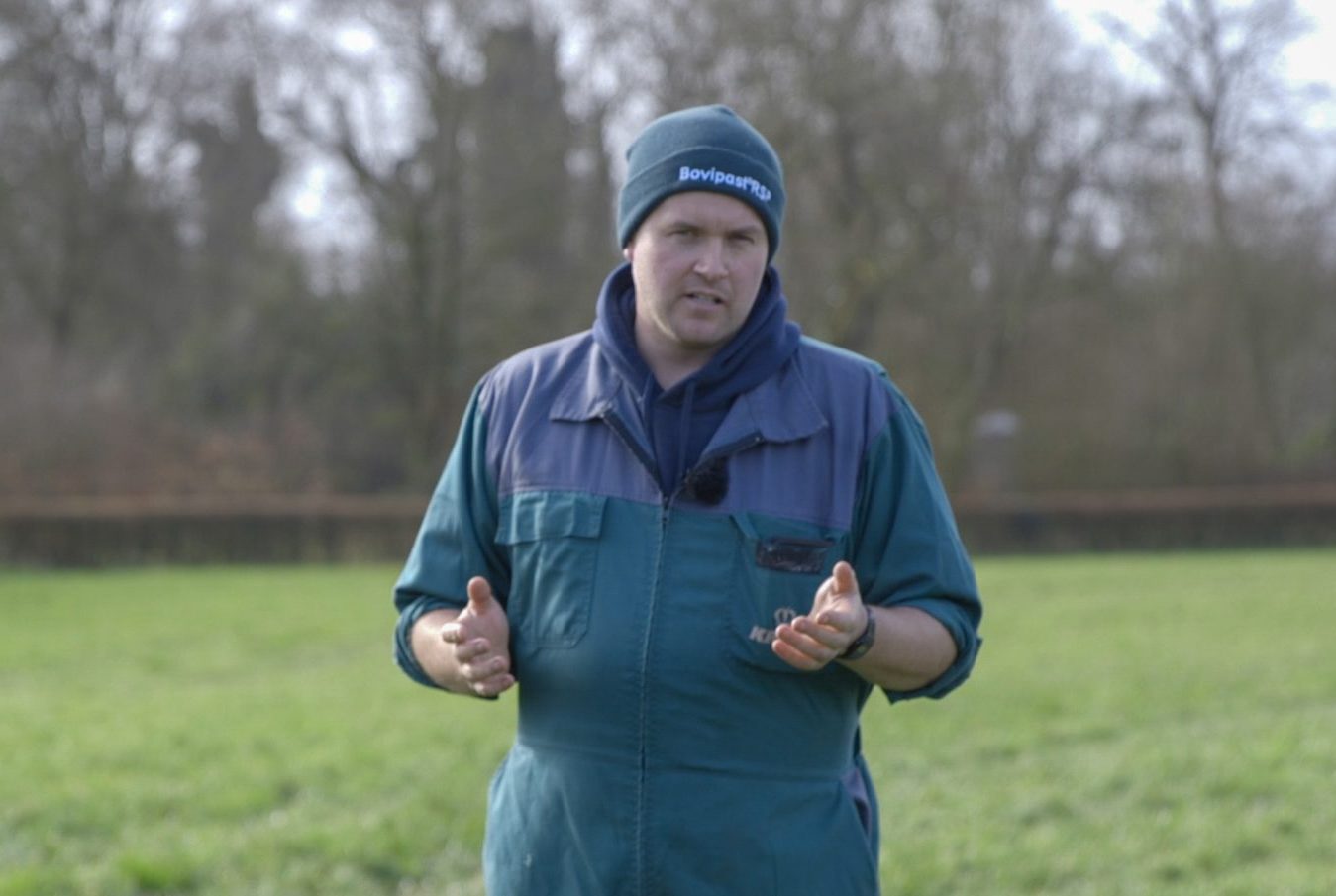 Man in blue and purple jacket talking and looking at camera